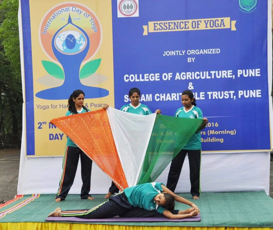 Students demonstrating yoga postures on stage at a community event