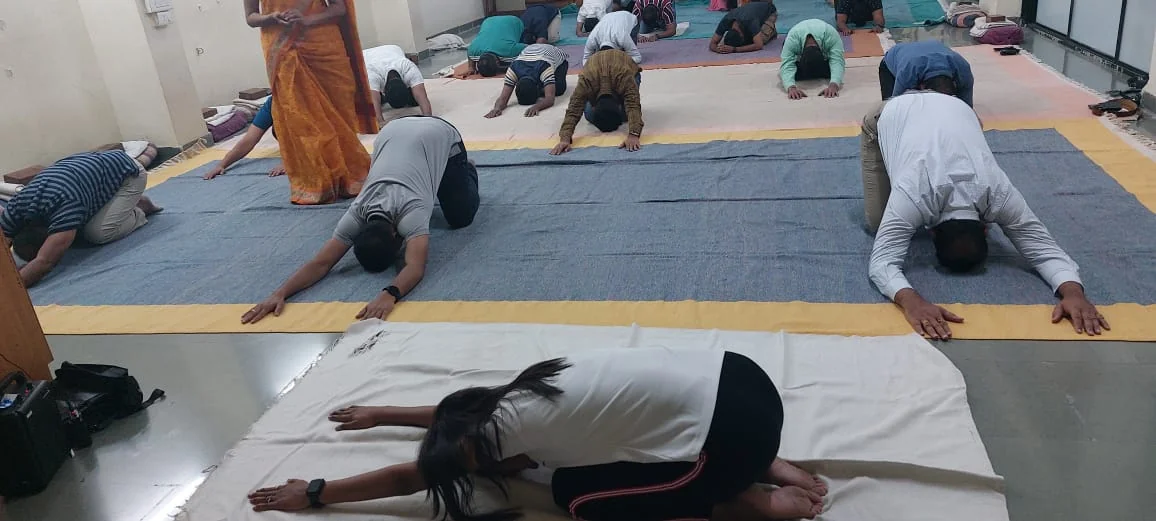Students practising seated forward bends together at the Pune institute