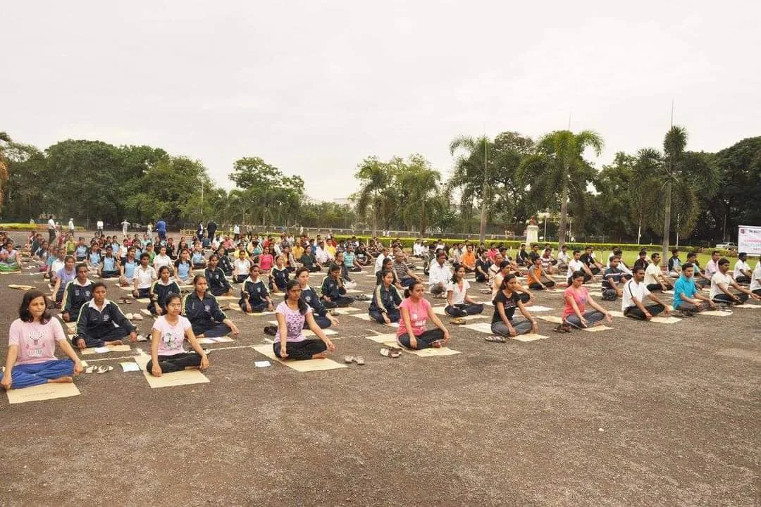 A community of students practising yoga together in an open park